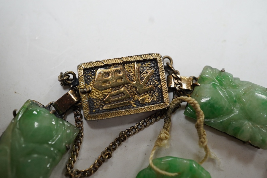 A Chinese gilt white metal and carved jade panel set bracelet, a.f, 17.5cm, together with a carved jade pendant, 40mm. Condition - poor to fair